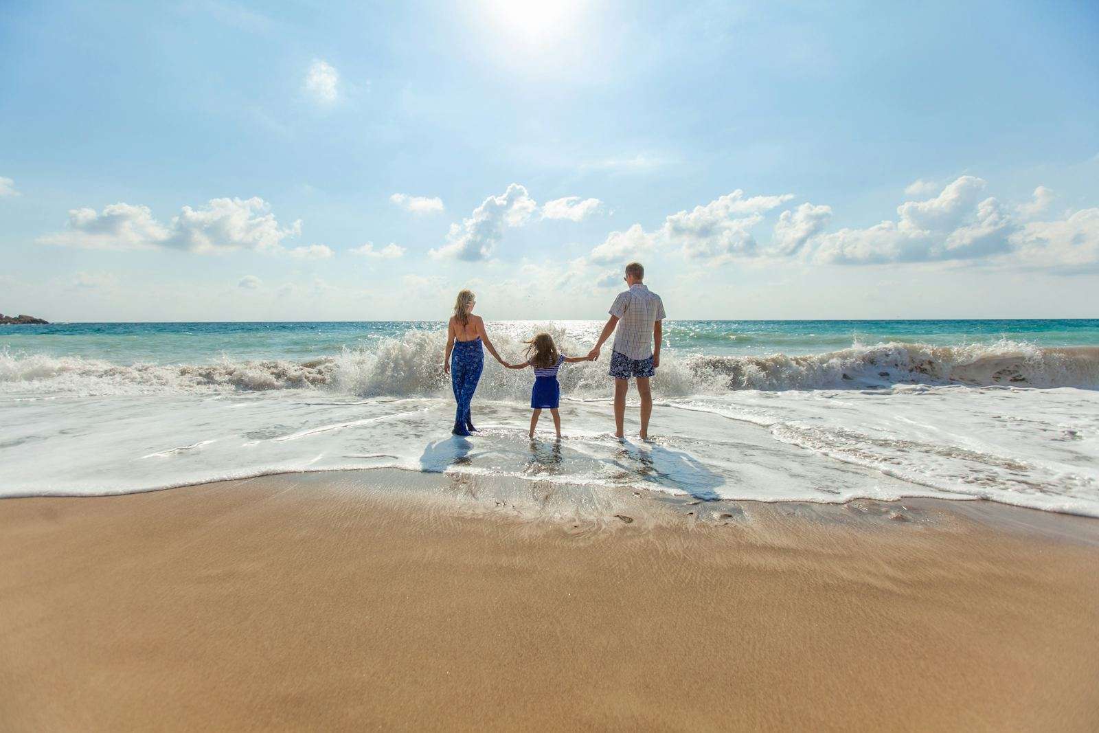 A family holding hands at the beach on vacation