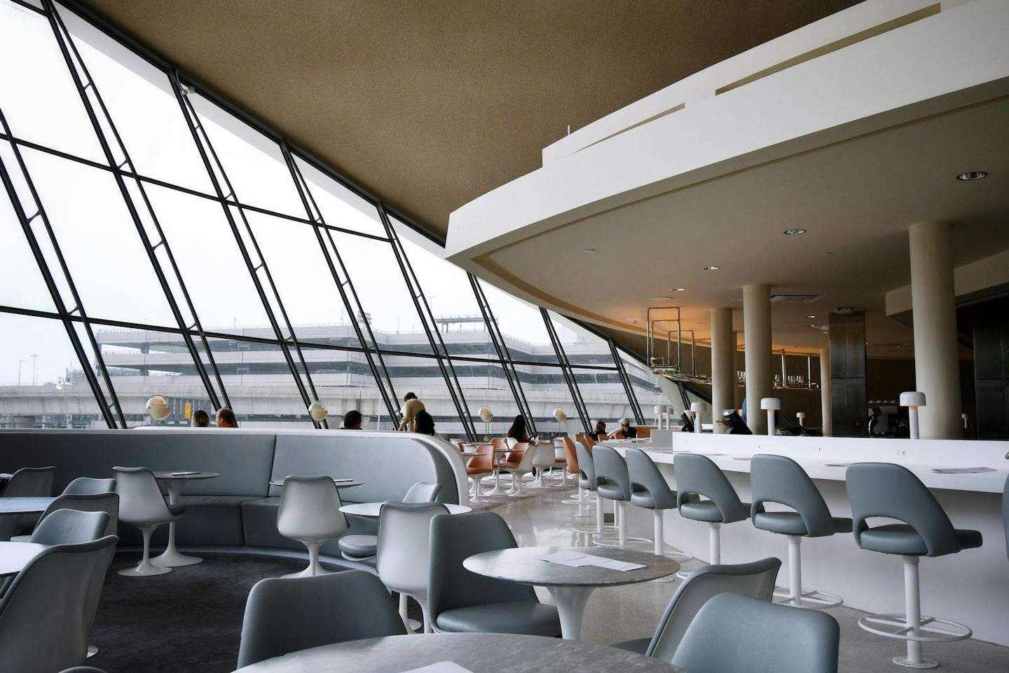 A calm, modern airport lounge with runway views
